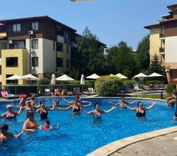 Спортен аниматор провежда аква аеробика в басейна с гости на хотела