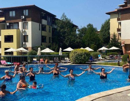 Спортен аниматор провежда аква аеробика в басейна с гости на хотела