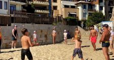 Спортен Аниматор води волейболна игра на плажа с туристи